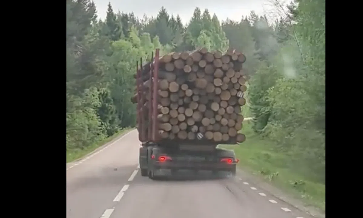 Vrachtwagen met lading boomstammen slingert onophoudelijk